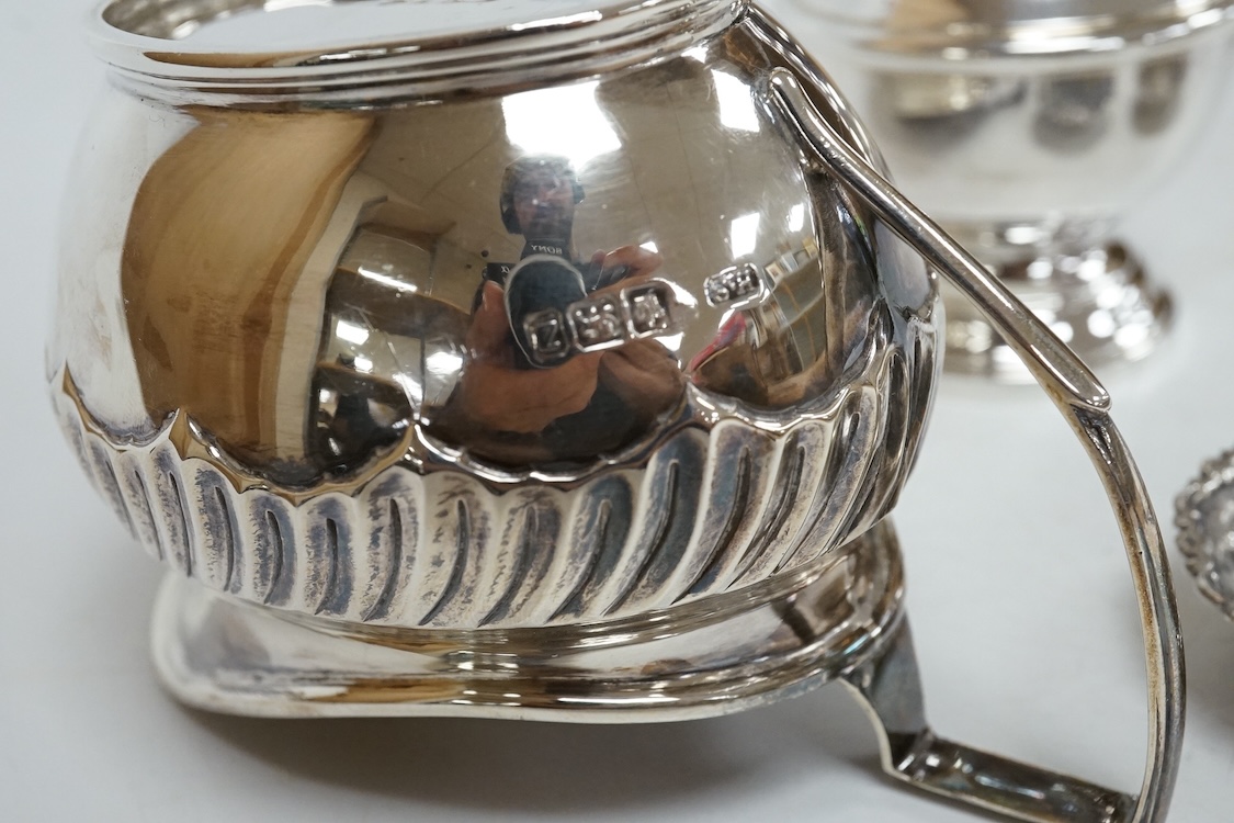 A 1970's silver sugar castor by SCR Ltd, London, 1973, 14.7cm, together with a small silver milk jug and a pair of late Victorian small silver dishes, Miller Brothers, Birmingham, 1899.